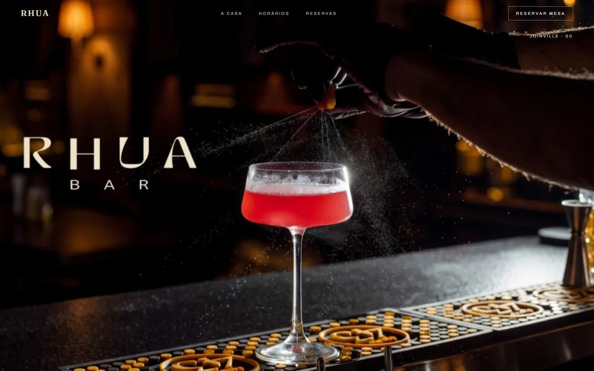 Site do RHUA Bar: fotografia de coquetel no balcão com o logotipo desenhado
